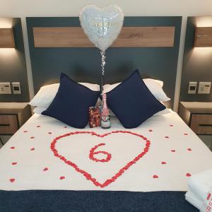 a heart drawn on a bed with a balloon and a bottle at The Paramount and The Supreme at Bellamare in Summerstrand