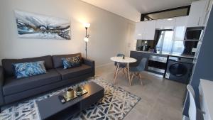 a living room with a couch and a kitchen at GQ Short Stays at Bellamare in Summerstrand +27 photos