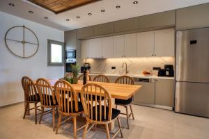 a kitchen and dining room with a wooden table and chairs at Costa Dorata Seaside villa in Chrissi Akti