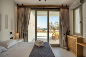 a bedroom with a bed with a stuffed animal on it at Costa Dorata Seaside villa in Chrissi Akti +94 photos
