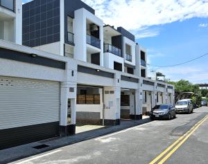 a building with cars parked on the side of a street at Jung House in Taitung City