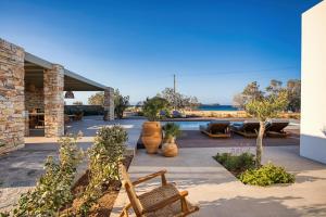 a patio with a bunch of plants and benches at Costa Dorata Seaside villa in Chrissi Akti