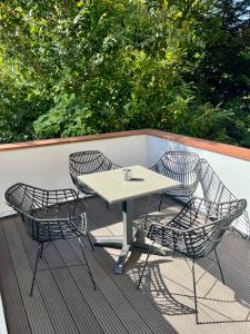 a table and three chairs on a deck at STADtPERLE in Itzehoe