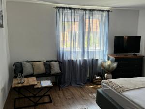 a bedroom with a bed and a window with a couch at Gabi's Home #3 in Sighişoara