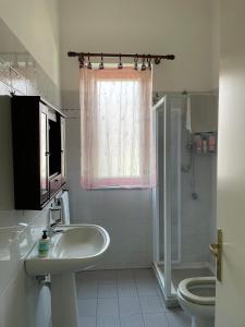 Un baño con lavabo, inodoro y ducha. en Tuttifrutti holiday, en Acireale