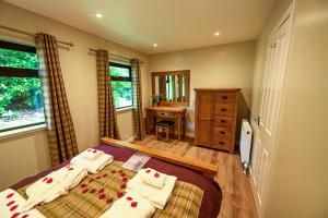 a bedroom with two beds and a desk in it at Bluebell Lodge 2 with Hot Tub in Newton Stewart