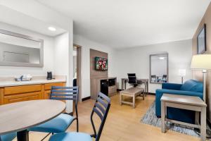 a living room with a blue couch and a table and chairs at Red Roof Inn Myrtle Beach Hotel - Market Commons in Myrtle Beach