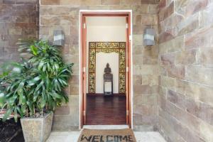 a door to a house with a stone wall at Villa Annecy in Seminyak