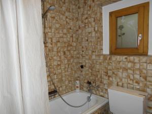 Das Bad ist mit einer Badewanne mit einer Dusche ausgestattet. in der Unterkunft Ferienwohnung Laax mit Traumblick, großem Balkon und Terrasse in Laax