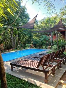 a group of lounge chairs next to a swimming pool at Villa Habarana in Habarana +25 photos
