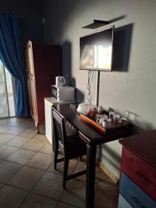 eine Küche mit einem Schreibtisch mit einer Lampe und einer Mikrowelle in der Unterkunft Big Tree Guesthouse Brits in Brits
