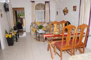 a living room with a wooden table and chairs at Rhyne Park Inn in Montego Bay