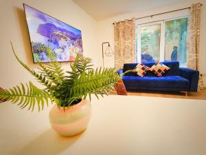 una sala de estar con una planta en un jarrón sobre una mesa en La Casita, Quarry - 2 bedroom Entire Apartment with Free Parking, en Glasgow