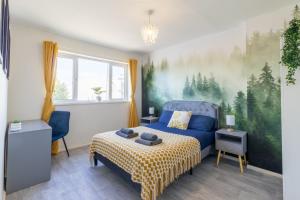 a bedroom with a blue bed and a painting on the wall at Open Mind Property - HotTUB, 4 Beds & 2 Free Parking in Portsmouth