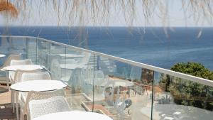 a balcony with tables and chairs and the ocean at Carvi Beach Hotel in Lagos