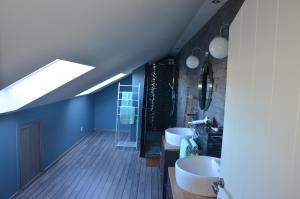 a bathroom with two sinks and a skylight at Les Champs aux Boules Ambiance très cosy in Herbeumont +8 photos