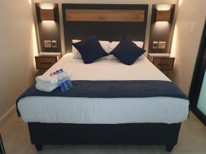 a bedroom with a large bed with towels and water bottles on it at The Paramount and The Supreme at Bellamare in Summerstrand +37 photos