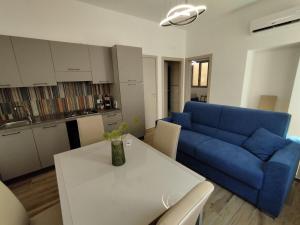 a living room with a blue couch and a table at appartament Suoro Palma in Marsala