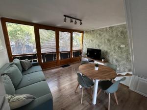 a living room with a couch and a table at Diána Apartman in Alsóörs