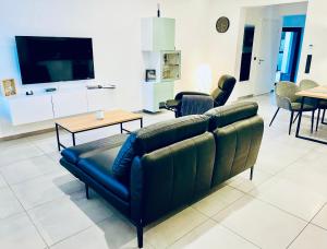 a living room with a couch and a tv at FeWo Mosel - Comfort & Relax in Treis-Karden