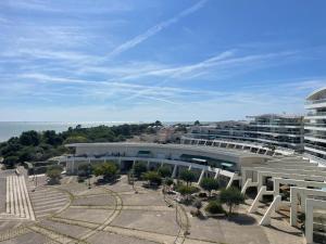 Ausblick auf ein Gebäude mit Meerblick im Hintergrund in der Unterkunft la voile de mer - studio tout confort proche plage in La Rochelle