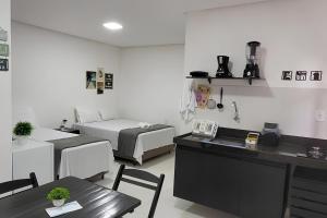 a room with two beds and a table and a kitchen at Águas da Barra in Maragogi