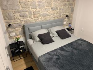 Bett in einem Zimmer mit einer Steinmauer in der Unterkunft Apartman Blue Moon Split- free parking in Split