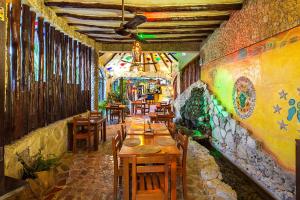 un restaurante con mesas de madera y una pared con graffiti en Maison Tulum, en Tulum