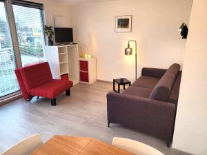 a living room with a couch and a red chair at Bright room with kitchen in Amsterdam