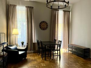 a living room with a table and chairs and a clock at Cent Hostel in Lublin