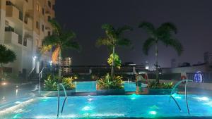 a swimming pool at night with palm trees at Manhattan Plaza 1 Araneta Cubao Sereene City BnB in Manila