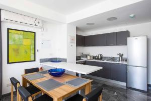 a kitchen with a table and a refrigerator at Villa Cerulean Paphos in Paphos City