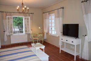 a living room with a tv and a bed at Moulin des Gypses Gîte Les Pierres Blanches, Ventoux in Mormoiron