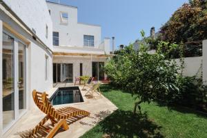 a backyard with chairs and a swimming pool at PugliaEclectic - A Modern Oasis in the Heart of Puglia in San Vito dei Normanni