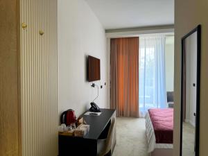 a hotel room with a bed and a desk with a phone at Ambar Hotel in Giurgiu