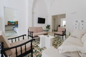 a living room with two couches and a tv at PugliaEclectic - A Modern Oasis in the Heart of Puglia in San Vito dei Normanni