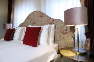 a bedroom with a large bed with red pillows at Het Ros van Twente in De Lutte