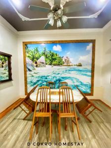 a dining room with a painting of the ocean at Dchokro Homestay Parit Raja UTHM in Parit Raja