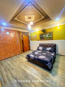 a bed in a room with a brick wall at Dchokro Homestay Parit Raja UTHM in Parit Raja