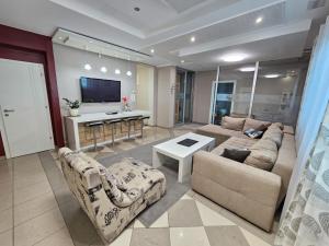 a living room with two couches and a flat screen tv at Apartmani EMA Bihać in Bihać