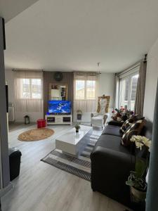 a living room with a couch and a tv at Terrasse de Paris in Poissy