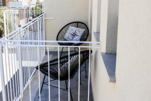 a black chair with a pillow on a balcony at Hotel Perla in Castiglione della Pescaia