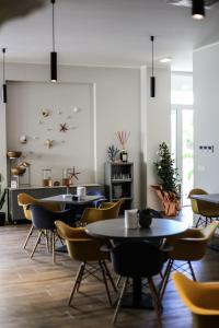 a restaurant with tables and chairs in a room at Hotel Perla in Castiglione della Pescaia