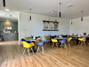 a restaurant with tables and yellow chairs in a room at Hotel Perla in Castiglione della Pescaia +37 photos