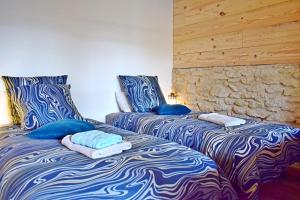 two beds sitting next to each other in a room at L'orée du bois gaubau in Saint-Georges-sur-Layon