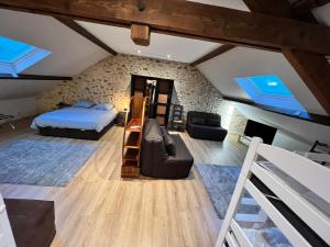 a attic bedroom with a bed and a couch at Gîtes du Domaine d'Auxonnettes L&J EVENEMENTS in Auxonnettes