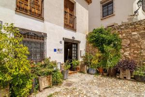 Un edificio con plantas en macetas en frente de él. en La casita de Paco Albaicin, en Granada