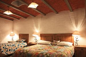sypialnia z 2 łóżkami i 2 światłami na suficie w obiekcie Cabaña Geranios Tequisquiapan w mieście Tequisquiapan