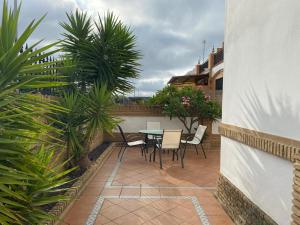 a patio with a table and chairs and plants at Costa Mazagón in Mazagón