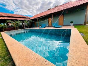 ein Swimmingpool vor einem Haus in der Unterkunft Recanto dos Sonhos - Rio Quente - Goiás in Rio Quente